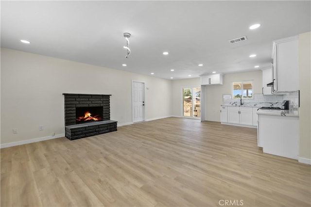 40635 159th St E, Lancaster, CA 93535 - unfurnished living room with recessed lighting, light wood finished floors, and a warm lit fireplace