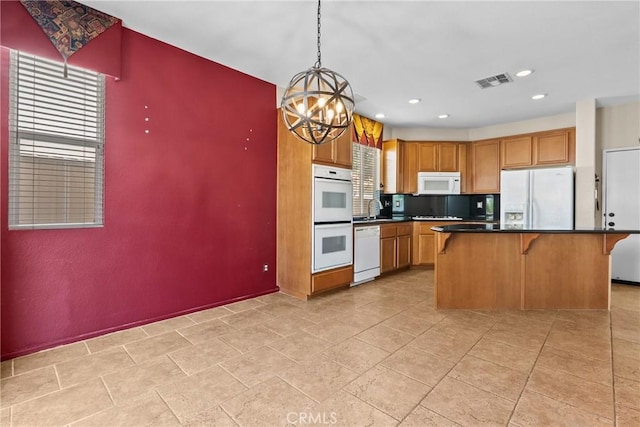 29513 Blake Way, Canyon Country, CA 91387 - kitchen featuring white appliances, a breakfast bar area, a chandelier, dark countertops, and hanging light fixtures