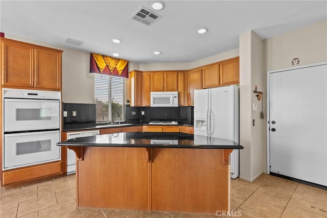 29513 Blake Way, Canyon Country, CA 91387 - kitchen featuring white appliances, a center island, a kitchen breakfast bar, dark countertops, and tasteful backsplash
