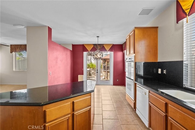 29513 Blake Way, Canyon Country, CA 91387 - kitchen with white appliances, a chandelier, hanging light fixtures, brown cabinetry, and a center island