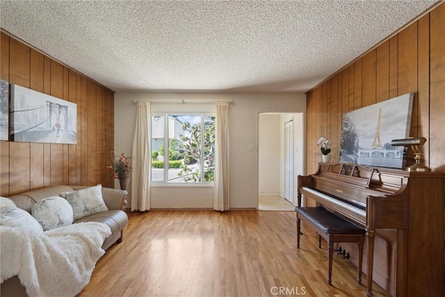 2012 Perry Ave, Redondo Beach, CA 90278 - living area with wooden walls, light wood-style flooring, and a textured ceiling