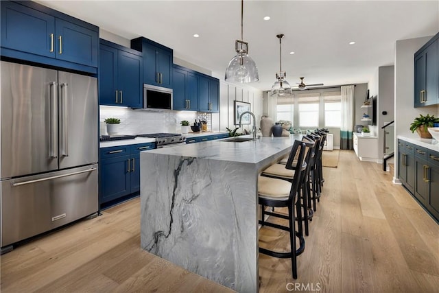 2626 Everly Dr, San Diego, CA 92108 - kitchen with appliances with stainless steel finishes, blue cabinets, ceiling fan, light wood-style flooring, and backsplash