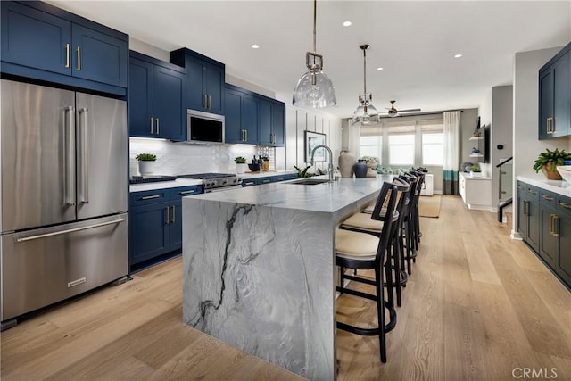 2626 Everly Dr, San Diego, CA 92108 - kitchen with appliances with stainless steel finishes, blue cabinets, ceiling fan, light wood-style flooring, and backsplash