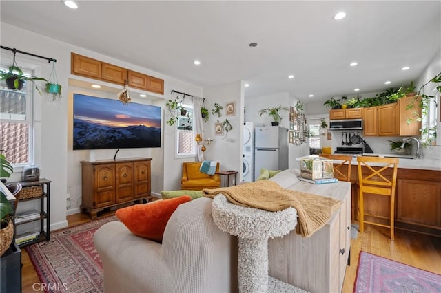 2848 S Kerckhoff Ave, San Pedro, CA 90731 - kitchen with freestanding refrigerator, stainless steel microwave, light wood finished floors, stacked washer / drying machine, and light countertops