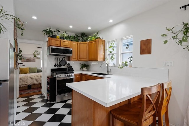 2848 S Kerckhoff Ave, San Pedro, CA 90731 - kitchen featuring appliances with stainless steel finishes, tile patterned floors, a peninsula, light countertops, and a kitchen bar