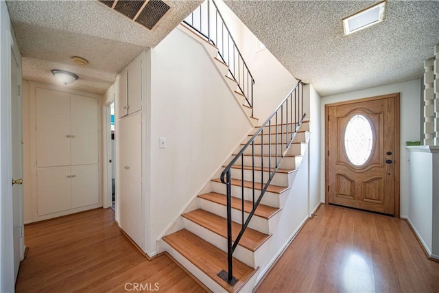 10415 Valley View Ave, Whittier, CA 90604 - foyer entrance featuring a textured ceiling, light wood-style flooring, and stairs