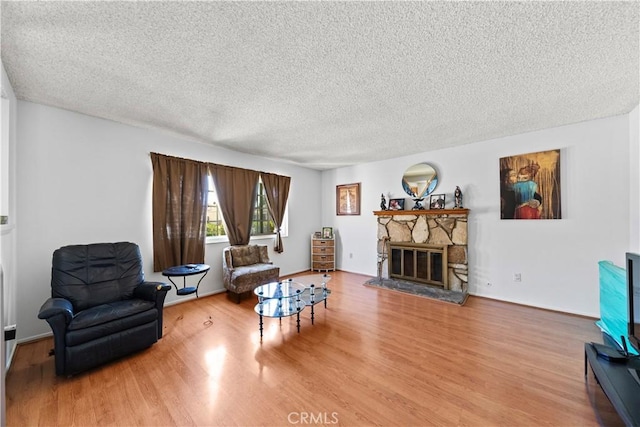 10415 Valley View Ave, Whittier, CA 90604 - living area with wood finished floors, a textured ceiling, and a stone fireplace