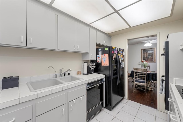 3500 W Manchester Blvd Unit 240, Inglewood, CA 90305 - kitchen featuring black appliances, tile counters, a ceiling fan, light tile patterned floors, and white cabinetry