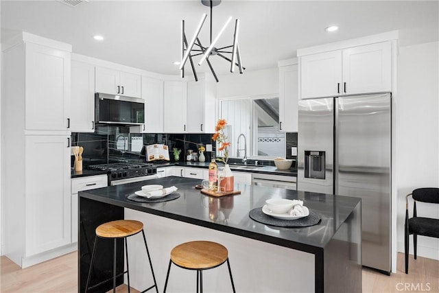 8771 La Grand Ave, Garden Grove, CA 92841 - kitchen featuring stainless steel appliances, dark countertops, backsplash, white cabinets, and recessed lighting