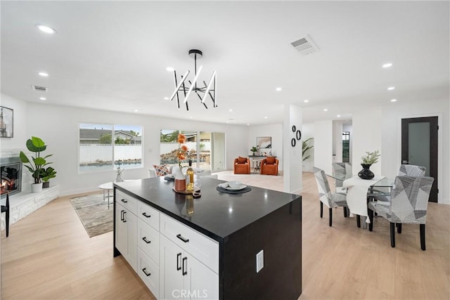 8771 La Grand Ave, Garden Grove, CA 92841 - kitchen featuring open floor plan, light wood finished floors, dark countertops, recessed lighting, and white cabinets