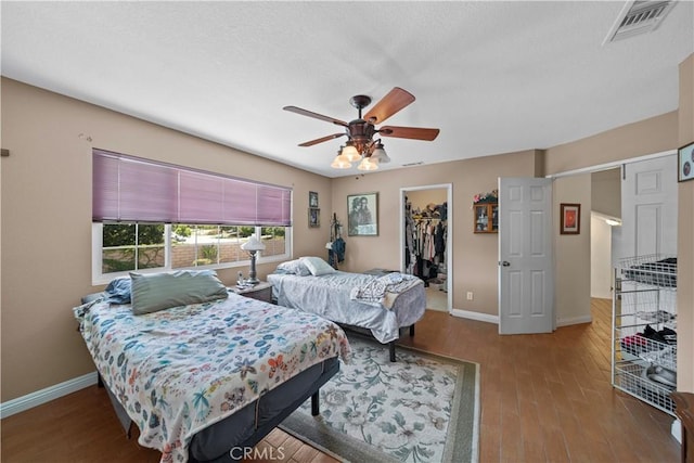 1142 Daisy Cir, Corona, CA 92882 - bedroom with a walk in closet, wood finished floors, a closet, and ceiling fan