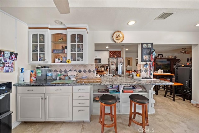 1142 Daisy Cir, Corona, CA 92882 - kitchen with appliances with stainless steel finishes, glass insert cabinets, white cabinets, dark stone counters, and recessed lighting