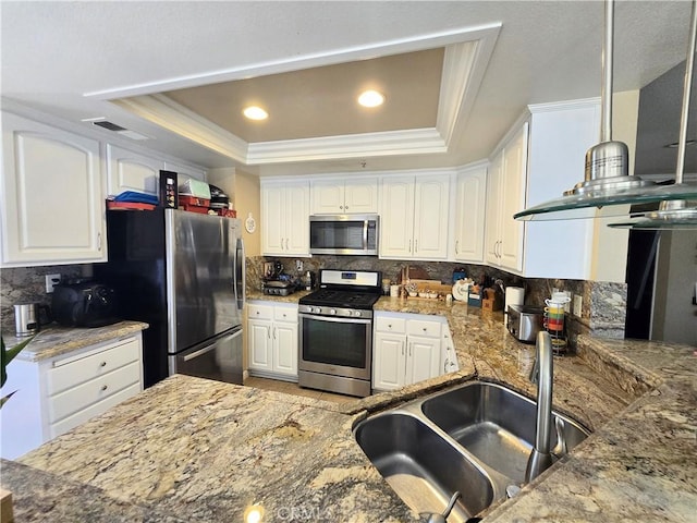 25632 Salerno Way, Yorba Linda, CA 92887 - kitchen with stainless steel appliances, a tray ceiling, backsplash, white cabinetry, and crown molding