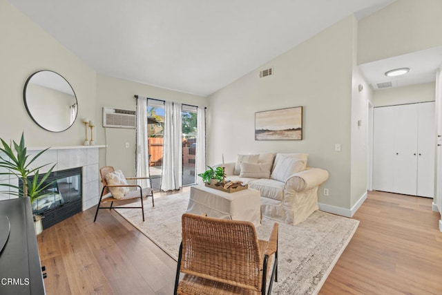 107 B St, Fillmore, CA 93015 - living room with a wall mounted AC, wood finished floors, a tile fireplace, and lofted ceiling