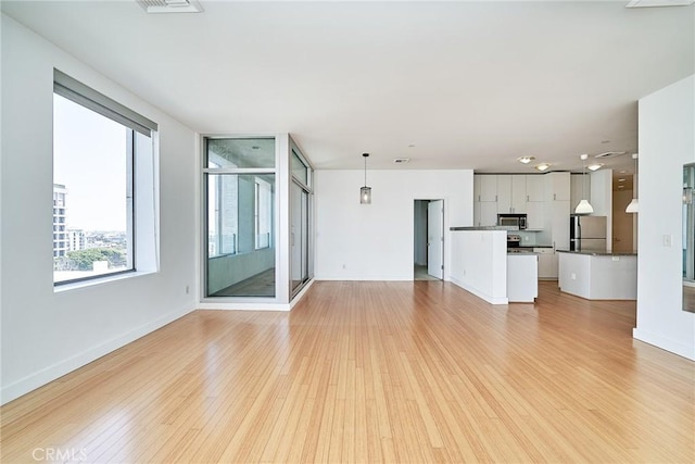 3810 Wilshire Blvd Unit 805, Los Angeles, CA 90010 - unfurnished living room featuring light wood-style floors and baseboards