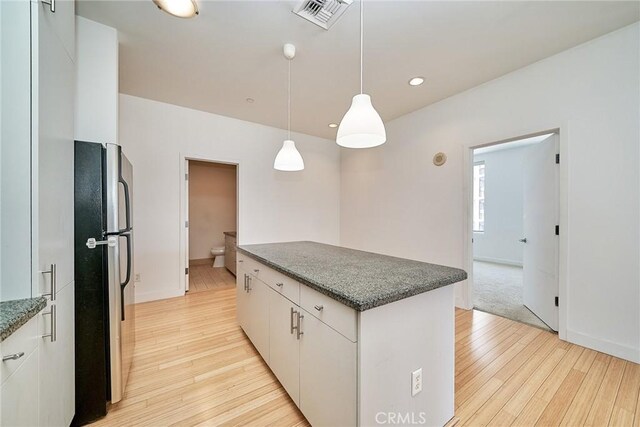 3810 Wilshire Blvd Unit 805, Los Angeles, CA 90010 - kitchen featuring freestanding refrigerator, a kitchen island, light wood-style flooring, white cabinetry, and recessed lighting