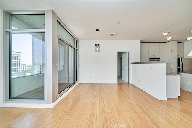 3810 Wilshire Blvd Unit 805, Los Angeles, CA 90010 - unfurnished living room featuring light wood-style flooring and baseboards