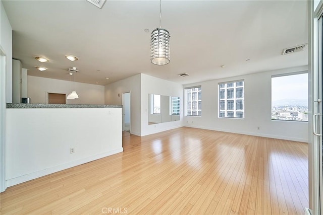 3810 Wilshire Blvd Unit 805, Los Angeles, CA 90010 - unfurnished living room featuring light wood-type flooring and baseboards