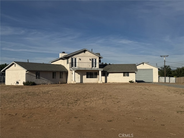 20635 Tonawanda Rd, Apple Valley, CA 92307 - back of house featuring a balcony, stucco siding, and a chimney