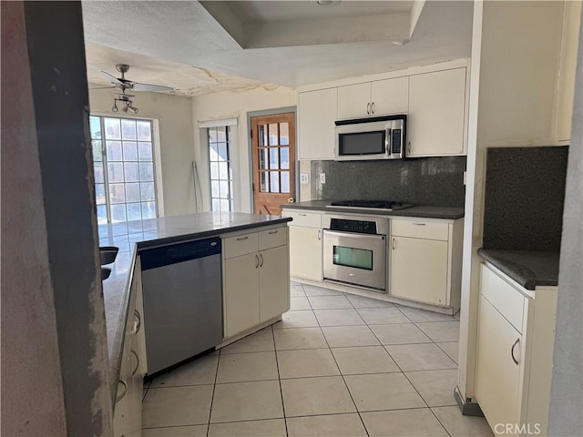 20635 Tonawanda Rd, Apple Valley, CA 92307 - kitchen featuring stainless steel appliances, dark countertops, backsplash, a tray ceiling, and a ceiling fan