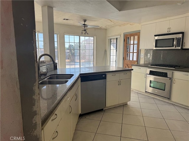 20635 Tonawanda Rd, Apple Valley, CA 92307 - kitchen with stainless steel appliances, ceiling fan, light tile patterned floors, decorative backsplash, and healthy amount of natural light