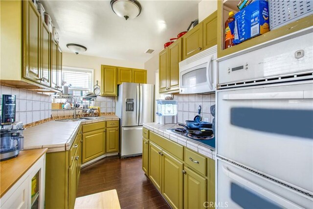 2685 Arrow Hwy, La Verne, CA 91750 - kitchen with stainless steel appliances, tile counters, decorative backsplash, and dark wood-style flooring