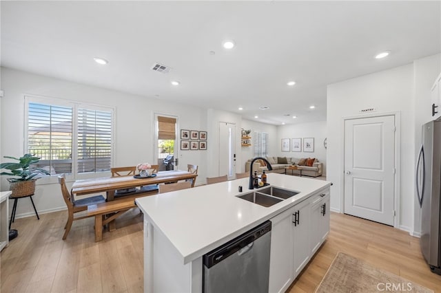 1060 Kendale Way, Vista, CA 92081 - kitchen with stainless steel appliances, light wood-style floors, white cabinetry, a kitchen island with sink, and light countertops