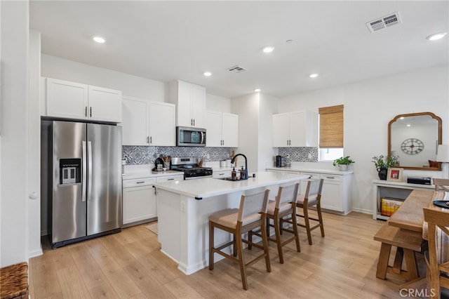 1060 Kendale Way, Vista, CA 92081 - kitchen featuring appliances with stainless steel finishes, light wood finished floors, white cabinetry, tasteful backsplash, and recessed lighting