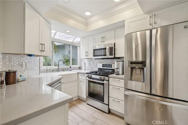 306 San Nicholas Ct, Laguna Beach, CA 92651 - kitchen with stainless steel appliances, ornamental molding, light countertops, white cabinets, and backsplash