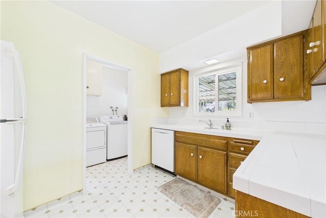 10469 Gregory Cir, Cypress, CA 90630 - kitchen with white appliances, washer and clothes dryer, brown cabinets, and light floors