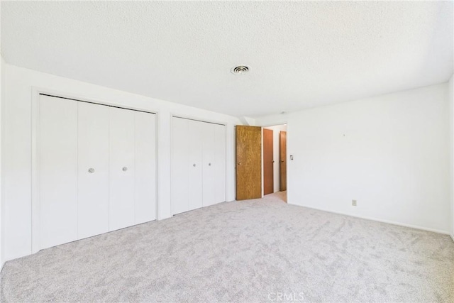 10469 Gregory Cir, Cypress, CA 90630 - unfurnished bedroom with carpet flooring, two closets, and a textured ceiling
