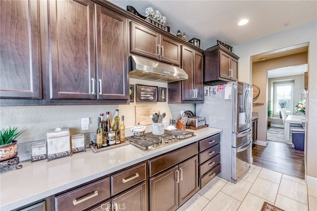 14655 Spanish Bay Way, Chowchilla, CA 93610 - kitchen with under cabinet range hood, stainless steel appliances, light countertops, dark brown cabinets, and recessed lighting