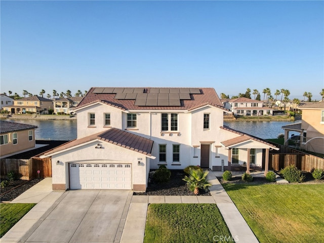 14655 Spanish Bay Way, Chowchilla, CA 93610 - mediterranean / spanish-style house with stucco siding, roof mounted solar panels, concrete driveway, a water view, and a tiled roof