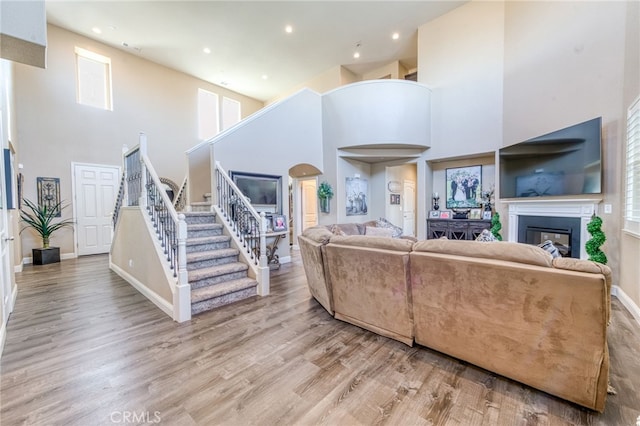 14655 Spanish Bay Way, Chowchilla, CA 93610 - living room featuring a glass covered fireplace, stairway, a towering ceiling, wood finished floors, and recessed lighting