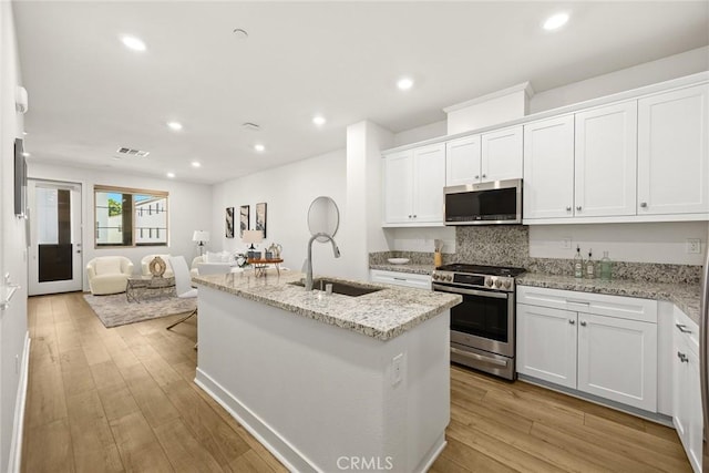 24 Bedford Ct, Arcadia, CA 91007 - kitchen with appliances with stainless steel finishes, recessed lighting, white cabinetry, light wood-style floors, and an island with sink