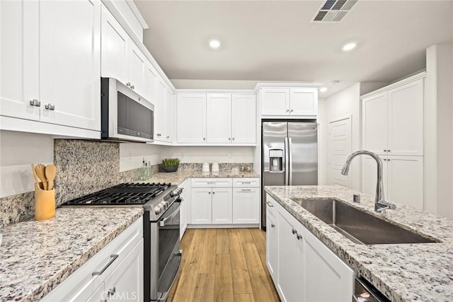 24 Bedford Ct, Arcadia, CA 91007 - kitchen featuring stainless steel appliances, white cabinetry, recessed lighting, light wood-style floors, and light stone countertops