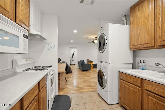 1140 W Lancaster Blvd, Lancaster, CA 93534 - kitchen featuring white appliances, stacked washer / dryer, brown cabinets, recessed lighting, and light countertops