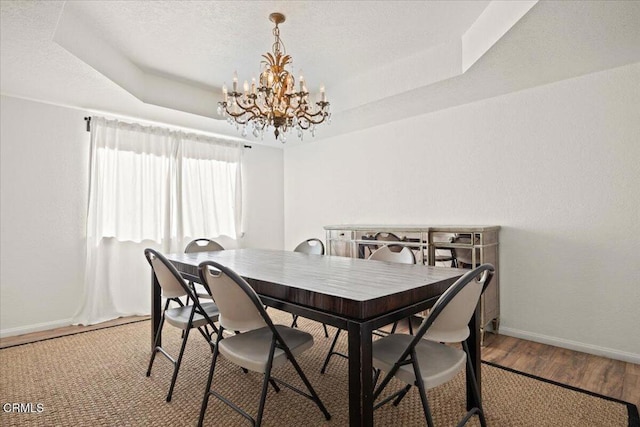 1140 W Lancaster Blvd, Lancaster, CA 93534 - dining space with a chandelier, a tray ceiling, and wood finished floors