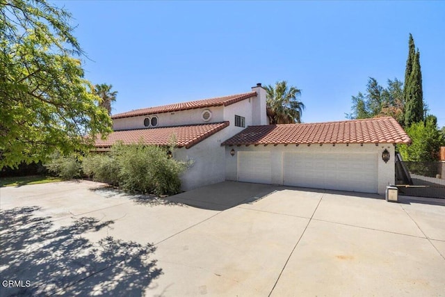 1140 W Lancaster Blvd, Lancaster, CA 93534 - mediterranean / spanish-style house with a garage, concrete driveway, stucco siding, a tile roof, and a chimney