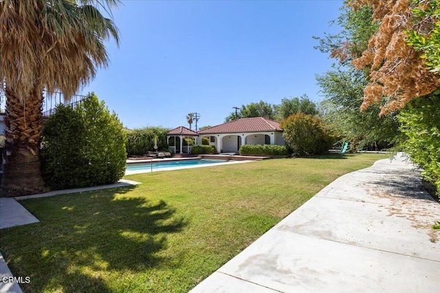 1140 W Lancaster Blvd, Lancaster, CA 93534 - view of grassy yard with a gazebo, an outdoor pool, concrete driveway, and an attached garage