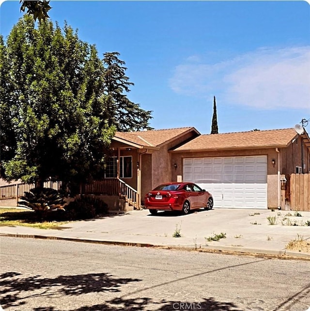 9250 Latham Dr, Planada, CA 95365 - view of front of home featuring concrete driveway, an attached garage, and stucco siding