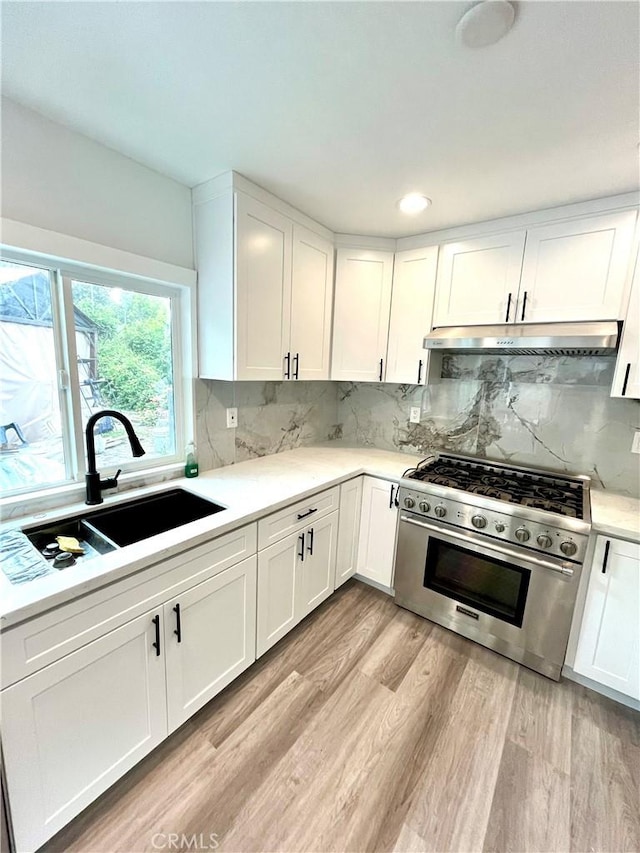 125 Campanita Ct, Monterey Park, CA 91754 - kitchen with stainless steel range, under cabinet range hood, light countertops, light wood-type flooring, and white cabinets