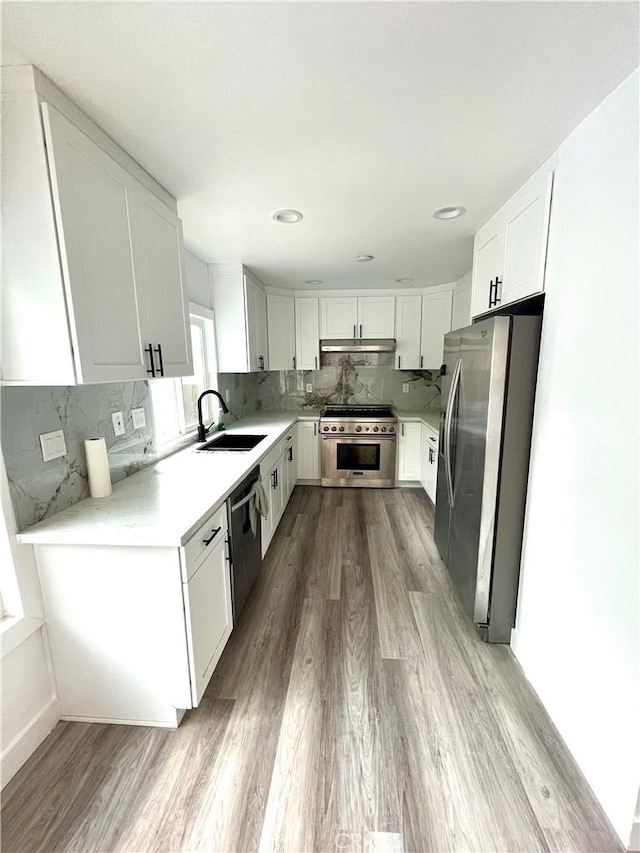 125 Campanita Ct, Monterey Park, CA 91754 - kitchen featuring stainless steel appliances, under cabinet range hood, light wood finished floors, and backsplash