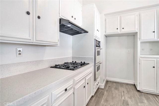 6470 Flamingo Dr, Buena Park, CA 90620 - kitchen featuring gas stovetop, under cabinet range hood, double wall oven, white cabinets, and light countertops