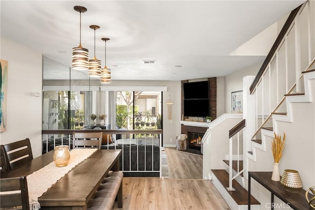 314 Molokai Dr, Placentia, CA 92870 - dining room with light wood-style flooring, stairway, and a brick fireplace