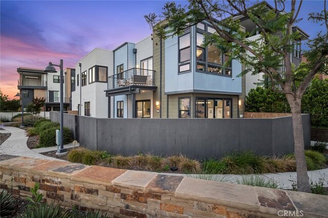 160 Mirth, Irvine, CA 92618 - property exterior at dusk featuring a fenced front yard and a balcony