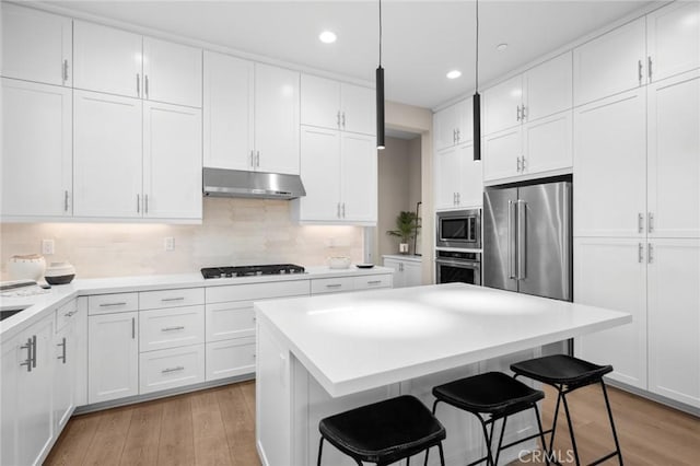 160 Mirth, Irvine, CA 92618 - kitchen with stainless steel appliances, under cabinet range hood, white cabinets, a center island, and a breakfast bar area