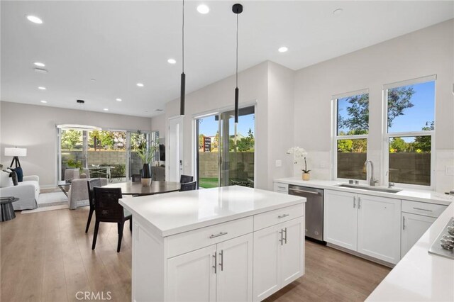 160 Mirth, Irvine, CA 92618 - kitchen with stainless steel dishwasher, recessed lighting, light wood-style flooring, hanging light fixtures, and white cabinetry