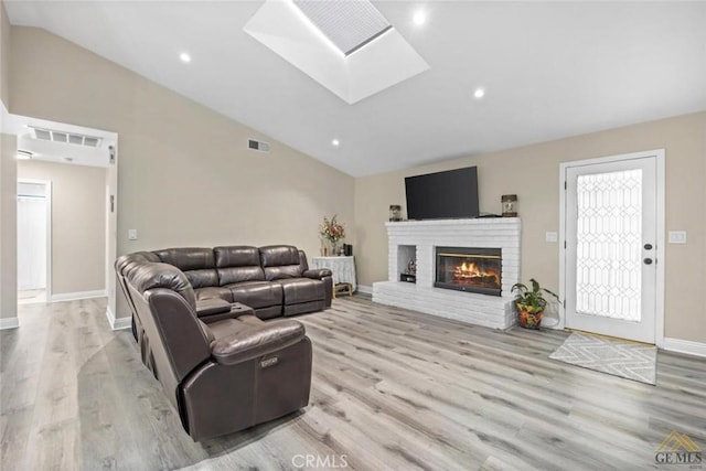 3105 Whisper Oak Way, Bakersfield, CA 93311 - living area with a skylight, wood finished floors, a brick fireplace, high vaulted ceiling, and recessed lighting