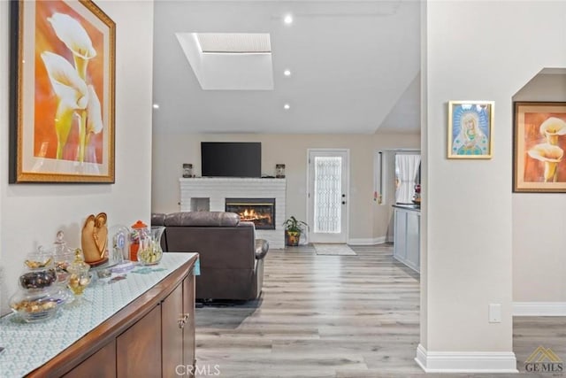 3105 Whisper Oak Way, Bakersfield, CA 93311 - living room featuring light wood finished floors, a brick fireplace, lofted ceiling, and a skylight